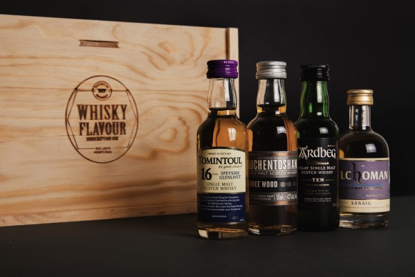 4 miniature whisky expressions near a wooden box